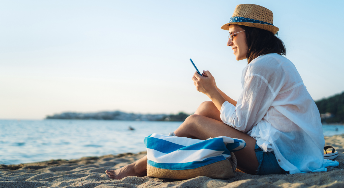 Lady on phone sitting on beach