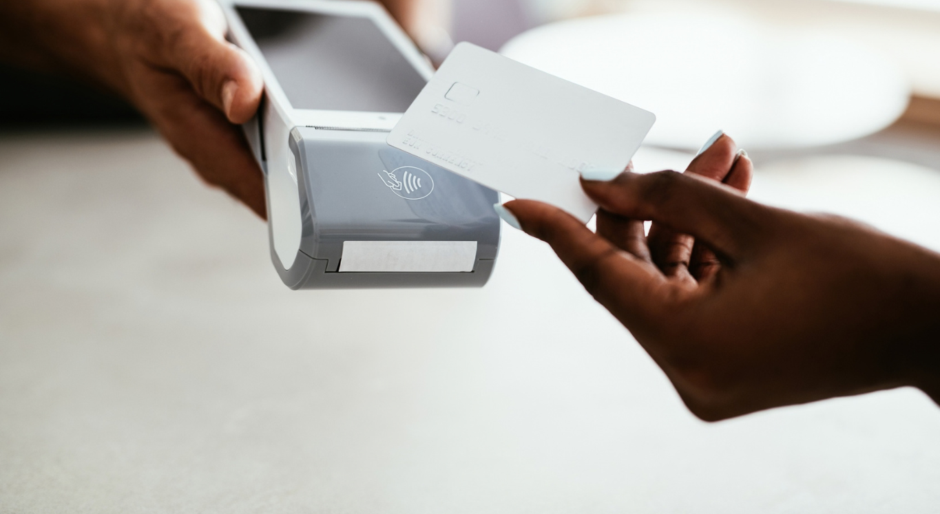Person tapping card on card reader to pay