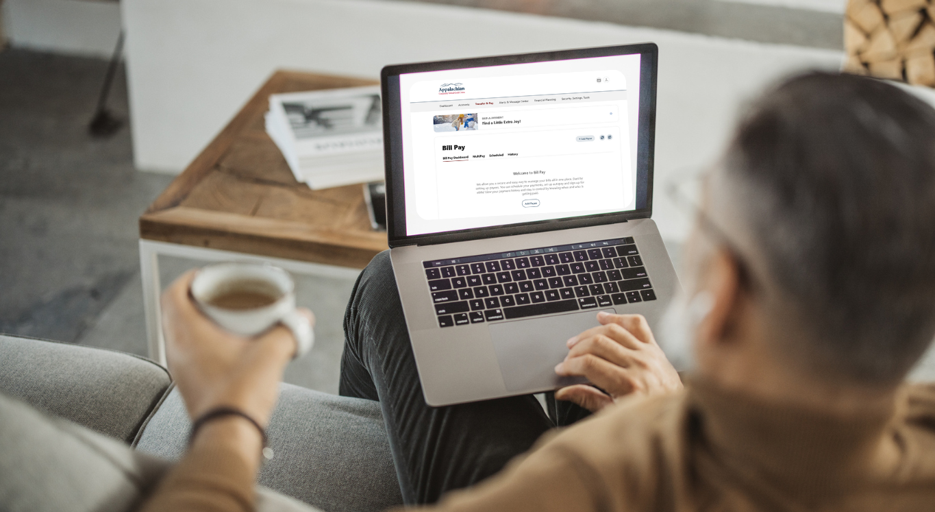 Image of man on computer with drink 